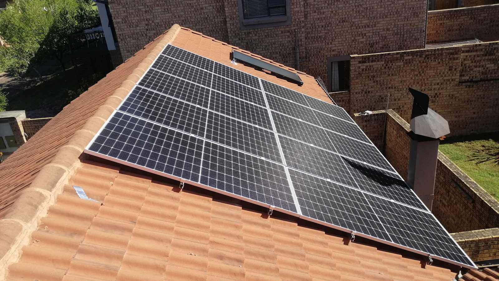 Rows of solar panels installed on a terracotta tile roof